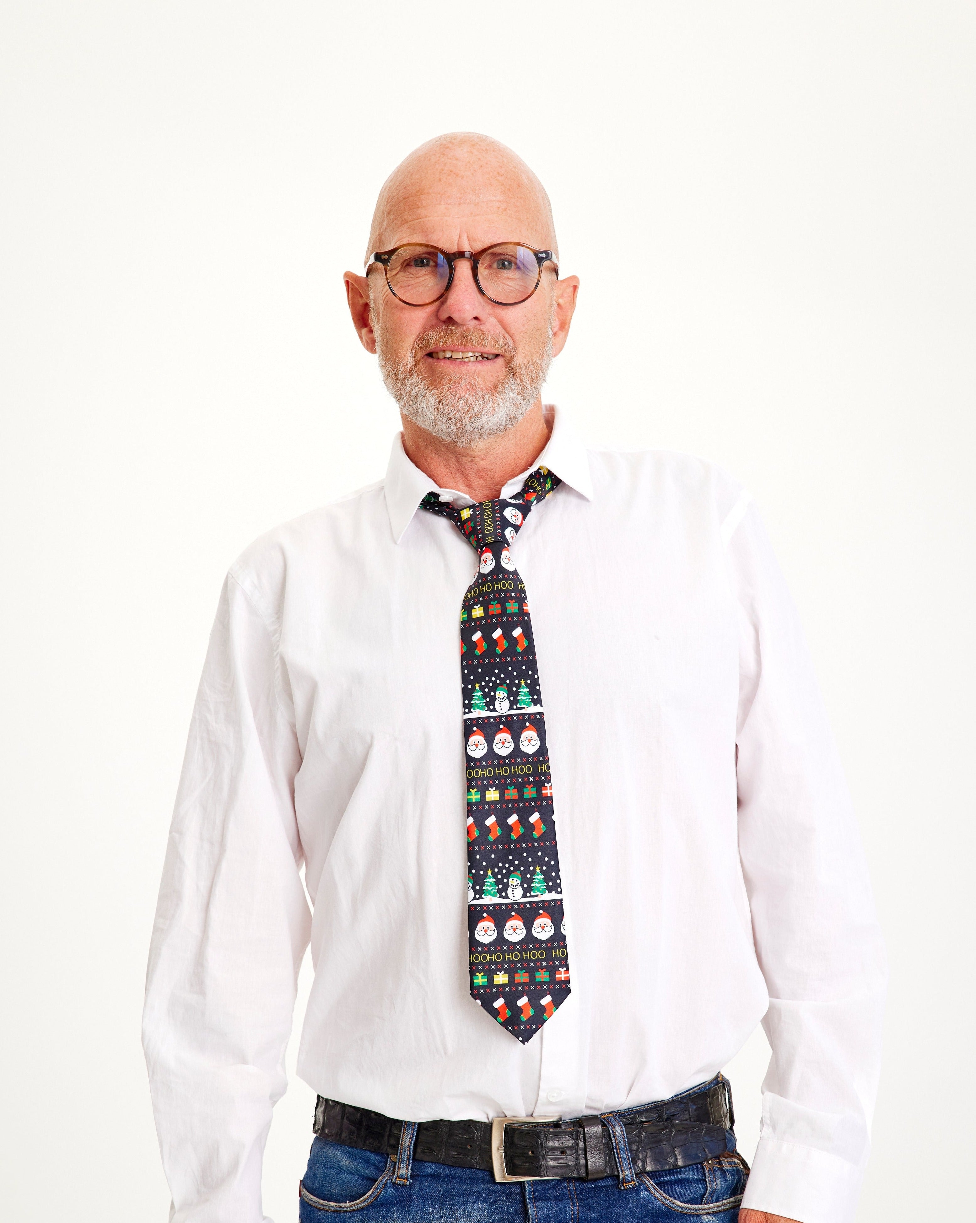 Een lachende man met een wit overhemd en een kerstdas.